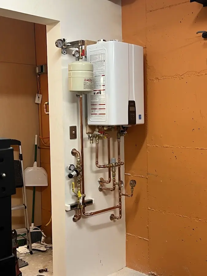 Plumbing technician inspecting water heater connections in Scottsboro